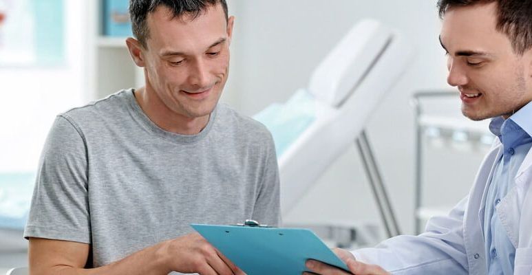 Lekarz pokazuje mężczyźnie wyniki badań profilaktycznych