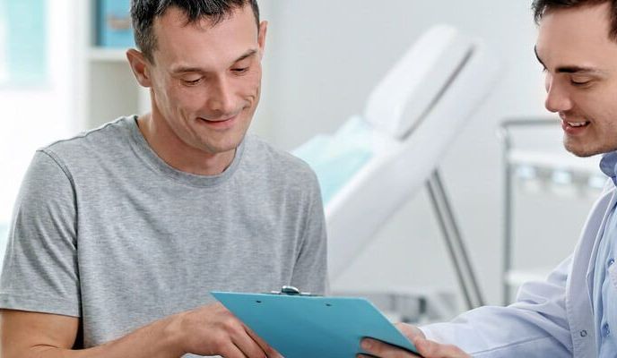 Lekarz pokazuje mężczyźnie wyniki badań profilaktycznych