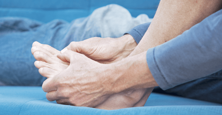 Chory na podagrę trzyma się za bolącą stopę